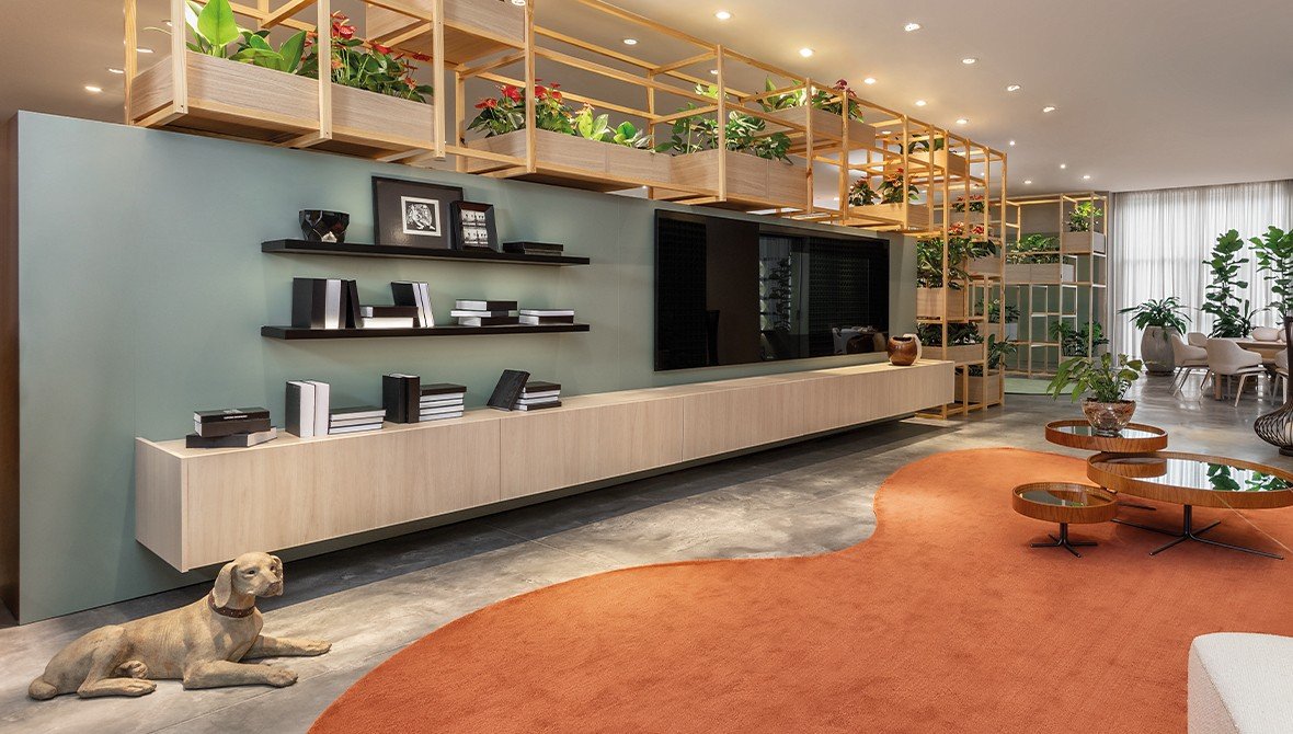 Living com imponente painel Todeschini que simula a textura de pedra natural, com rack integrado e iluminação de destaque.
