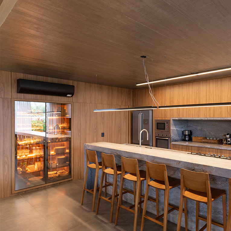 Cozinha planejada moderna integrada com a sala de estar, mostrando a tendência de ambientes abertos.